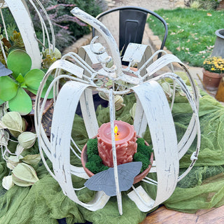 White metal pumpkin centerpiece with faux candle and greenery inside for rustic farmhouse table decor