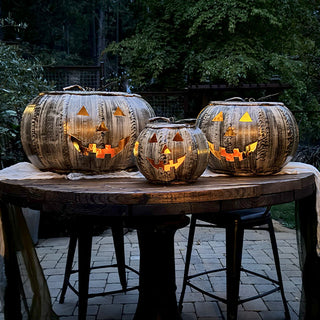 Three glowing metal pumpkin lanterns