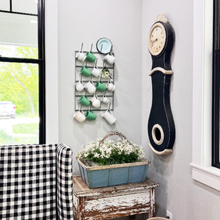 Close-up ceramic pitchers on metal mug rack