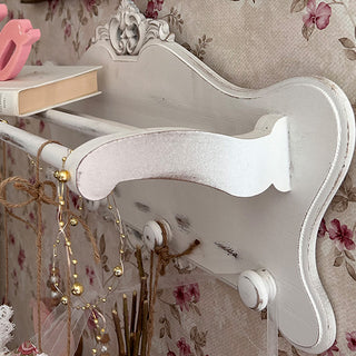 Vintage style white wall shelf with hooks and wooden dowel rods side view