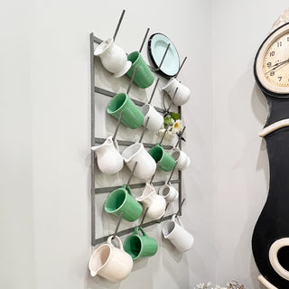 Decorative wall mug rack with green white cups


