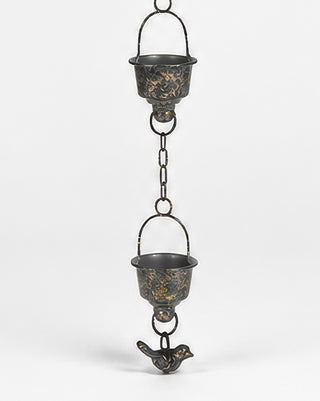Close-up of rain chain cups with golden patina detail
