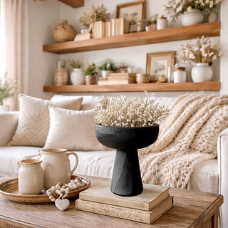Black wooden pedestal bowl styled on neutral living room table