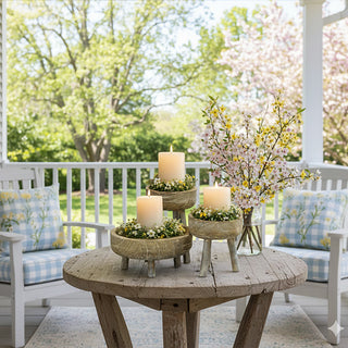 Set of three carved wood pedestal risers with tripod legs on farmhouse table