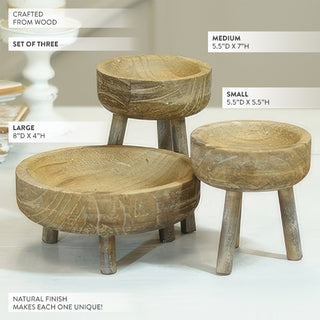 Natural wood bowl shaped riser with pillar candle and greenery display