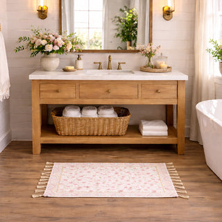 Bathroom with wooden vanity, sink, and decorative elements. Beautiful floral rug.
