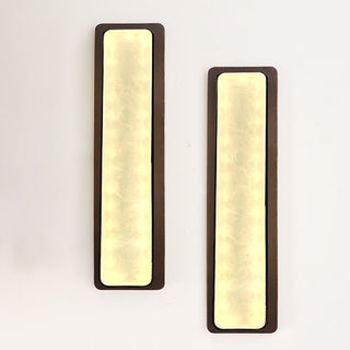 Set of two elongated LED sconces casting warm light on white background