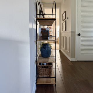 Side view of tall black metal and wood shelving unit showcasing slim design and open structure