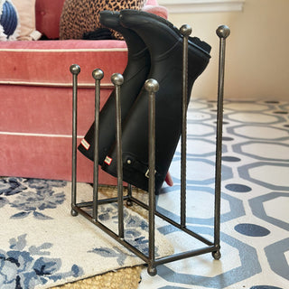 Iron boot rack holding black rain boots demonstrating storage capacity