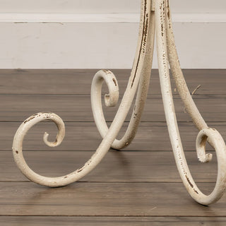 Scrolled metal legs detail of vintage cream accent table with distressed finish