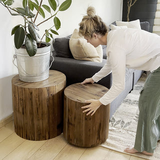 Rolling wood stump side table beside sofa