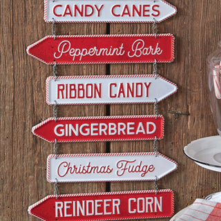  Detail of six directional arrow signs showing candy varieties including candy canes peppermint bark ribbon candy gingerbread fudge and reindeer corn

