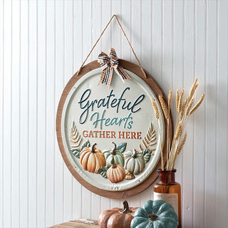 Detailed view of embossed pumpkins and lettering on 'Grateful Hearts Gather Here' rustic fall wall sign.