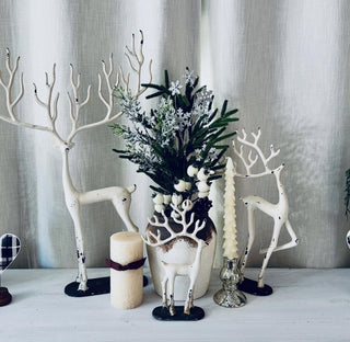 white reindeer with a white vase and candles
