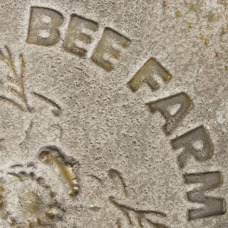  Decorative metal bee farm stake among white flowers and greenery