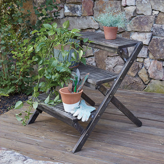 Foldable wooden plant shelf with gardening tools and plants