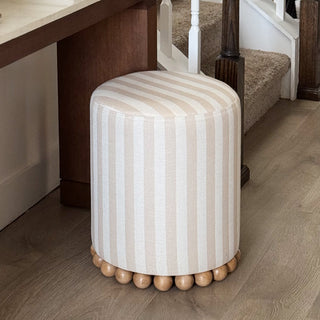 Neutral striped ottoman beside staircase entry decor
