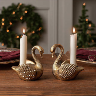 Vintage style gold swan candle holders with graceful curved necks for formal dinner party table setting