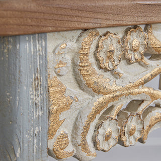 Close-up hand carved wood scrollwork detail gold accents distressed white finish French country console table