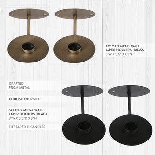 Set of 2 metal wall taper holders, one in brass and one in black, on a light wooden background.