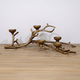 Cast iron branch tealight holder side profile view on wood surface showing sculptural tree branch design