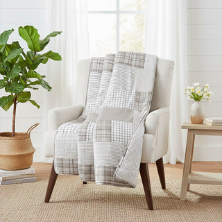 Neutral patchwork throw blanket on armchair living room