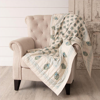 Block print throw draped over beige armchair showcasing traditional artisan printing technique