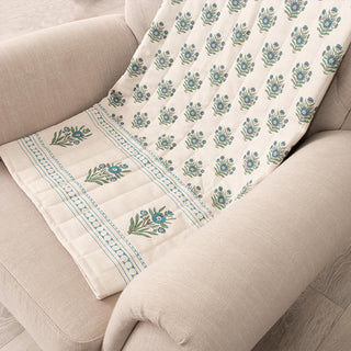 Block print throw on neutral chair showing repeating floral motifs and border detail