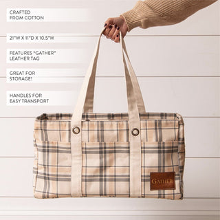 Close-up of neutral plaid tote with embossed leather Gather tag showing dimensions and cotton construction
