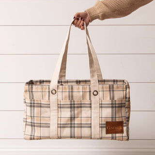 Full view of tan and brown plaid cotton tote bag with dual handles on white shiplap background