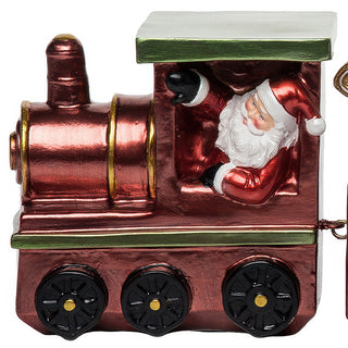 Close-up of Santa Claus figure leaning from red metallic train engine with green roof, showing hand-painted details and bronze wheel accents