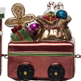 Middle train car filled with Santa's toy bag overflowing with wrapped presents, candy canes, ornaments and gingerbread man cookie on burgundy metallic train car