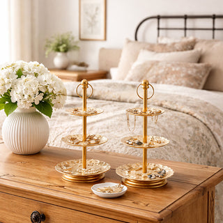 Gold three tier serving stand set with floral patterns on bedroom dresser