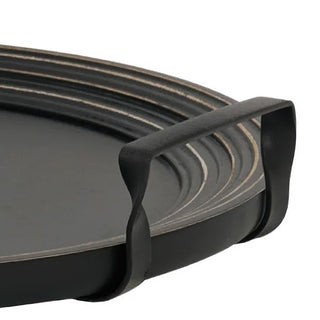 Close-up detail of curved metal handle and concentric groove rim design on black serving tray