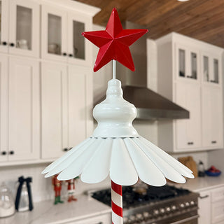 Close-up of red star topper and scalloped white metal tier on festive three-tier serving tray