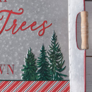 Detail view of natural wood handles and evergreen tree graphics on gray metal Christmas serving tray