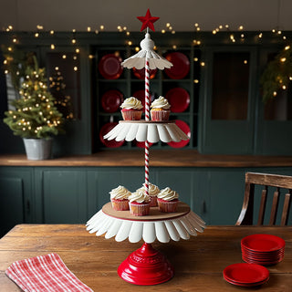 Christmas-themed three-tier cupcake stand with red star topper, red base, and cupcakes displayed in cozy holiday kitchen setting