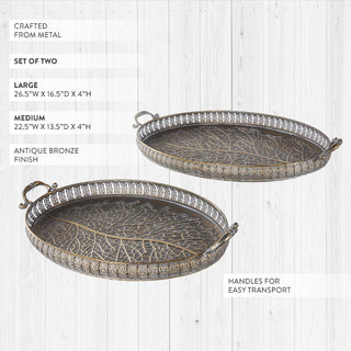 Large oval decorative tray with ornate handles and medallion border holding candles and vase centerpiece
