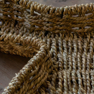 Close up detail of hand-woven seagrass bunny tray showing braided rope edge and weave pattern