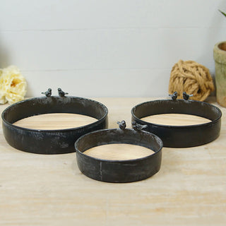 Three nesting metal trays with natural wood bottoms and decorative bird details

