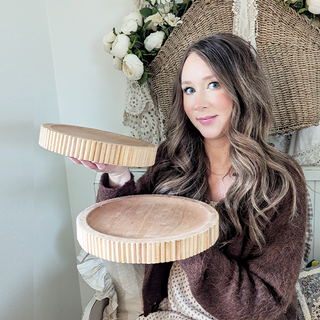 Woman holding round wooden serving trays home decor
