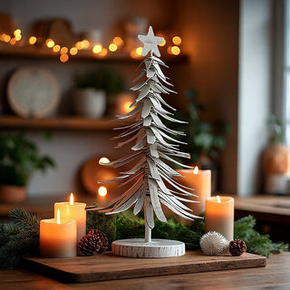 Vintage white metal Christmas tree centerpiece surrounded by pillar candles pine cones and evergreen garland on rustic wood tray
