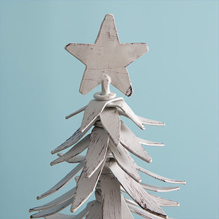 Close up detail of distressed white metal star tree topper and layered metal branches showing weathered farmhouse finish