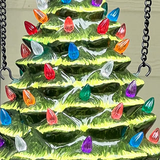 Close-up of ceramic Christmas tree with colorful LED lights for holiday porch decor