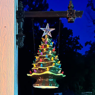 Light-up ceramic Christmas tree hanging porch decor glowing at night with LED multicolor lights
