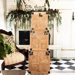 Stacked set of three carved wooden storage trunks with geometric panel detailing and metal hardware, styled in an elegant vintage living room for home décor and organization
