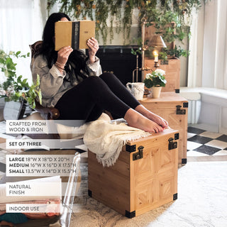 Stacked set of three carved wooden storage trunks with geometric panel detailing and metal hardware, styled in an elegant vintage living room for home décor and organization