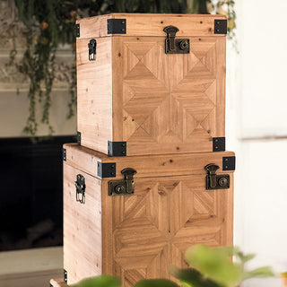Stacked set of three carved wooden storage trunks with geometric panel detailing and metal hardware