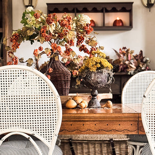 Decorative black urn with dried flowers on a wooden surface