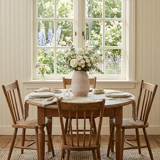 Ivory whitewash ceramic vase with flowers on farmhouse dining table